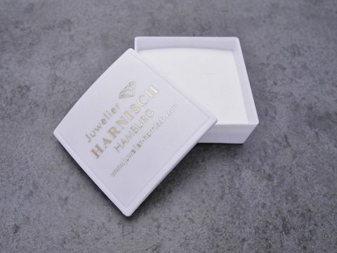 Geschenkschachtel 4 x 4 cm von Juwelier Harnisch, weiß mit goldener Prägung, geöffnet, innen mit weichem Material ausgekleidet, ideal für Schmuckgeschenke.