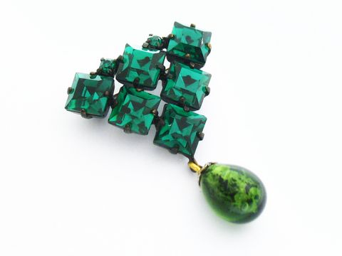 Grüne Strass Brosche mit sexy City Look, bestehend aus mehreren rechteckigen, facettierten grünen Steinen und einem tropfenförmigen Anhänger in Grün, Hersteller Juwelier Harnisch.