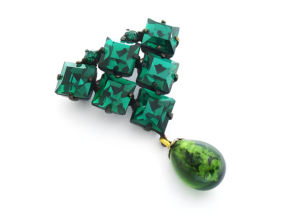 Grüne Strass Brosche mit sexy City Look, bestehend aus mehreren rechteckigen, facettierten grünen Steinen und einem tropfenförmigen Anhänger in Grün, Hersteller Juwelier Harnisch.