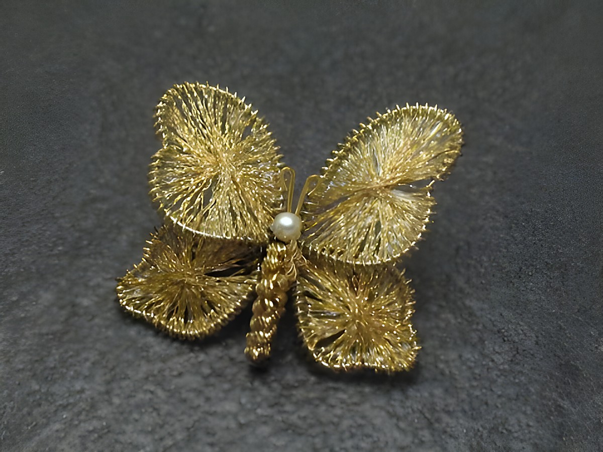 Filigrane Brosche Handarbeit 30x34 mm in Form eines Schmetterlings, hergestellt von Juwelier Harnisch, eleganter Modeschmuck mit feinen Details und einer kleinen Perle in der Mitte.