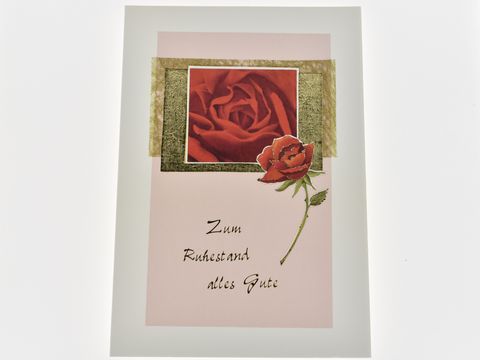 Eine Glückwunschkarte mit einem roten Rosenmotiv, goldenen und grünen Akzenten sowie dem Text "Zum Ruhestand alles Gute". Hersteller: Juwelier Harnisch, Glückwunschkarten.