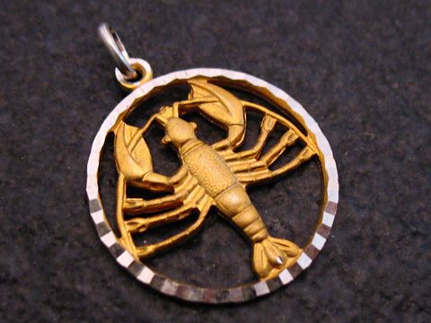 Sternzeichen Krebs Anhänger aus Gold auf einem runden Silbergrund, kunstvoll gestaltet mit der Darstellung eines Krebses, gefertigt vom Juwelier Harnisch.