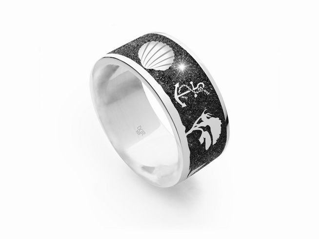 Der DUR Lavasand Ring Nachtring Ostsee in Größe 52 besteht aus Sterling Silber und zeigt eine schwarze Oberfläche mit einem Muschelmotiv und funkelnden Details.