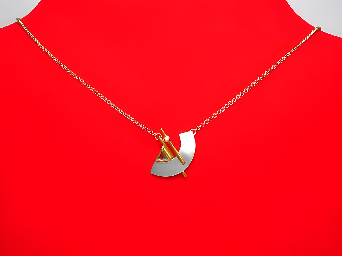 Collier Gold 375 Mittelteil bicolor mit Diamant und Topas, 45 cm lang, präsentiert auf einem roten Untergrund, elegant und modern gestaltet. Hersteller Juwelier Harnisch.