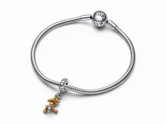 Charm-Anhänger von Pandora mit Tigger aus Disney Winnie Puuh, gefertigt aus Sterling Silber und transparentem orangefarbenem Emaille, an einem glitzernden Armband.
