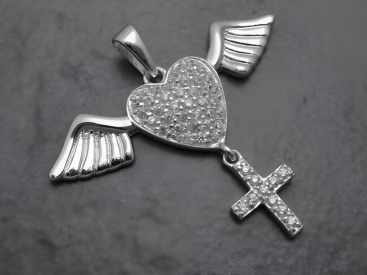 Ein Anhänger in Herzform mit Flügeln und einem Kreuz, aus rhodiniertem Sterling Silber und Zirkonia, hergestellt von Juwelier Harnisch, ideal für Schmuckliebhaber.