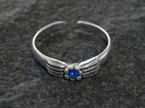Blüten Zehenring aus Sterling Silber in Dunkelblau, mit einem zentralen blauen Stein und feinen, geschwungenen Details, hergestellt von Juwelier Harnisch. Ideal für stilvolle Fußbekleidung.