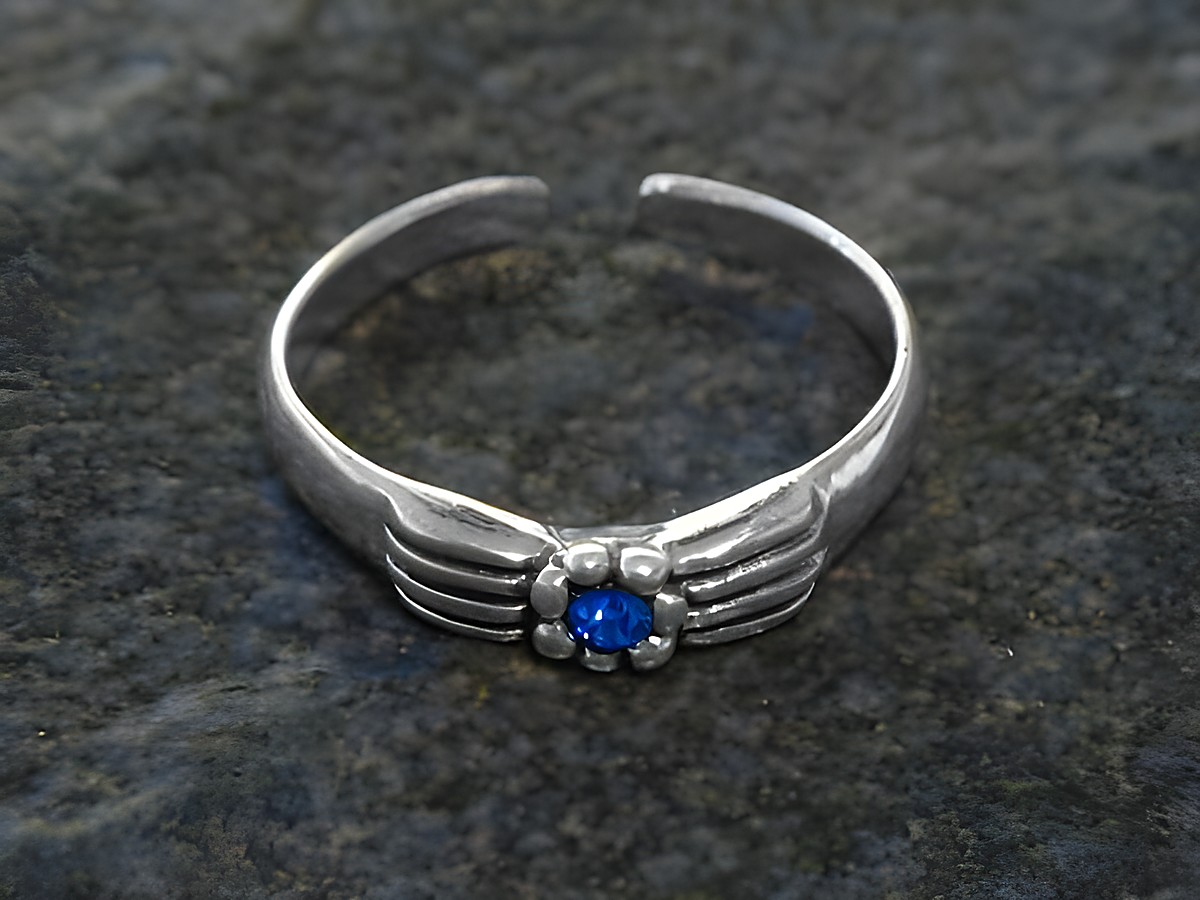 Blüten Zehenring aus Sterling Silber in Dunkelblau, mit einem zentralen blauen Stein und feinen, geschwungenen Details, hergestellt von Juwelier Harnisch. Ideal für stilvolle Fußbekleidung.