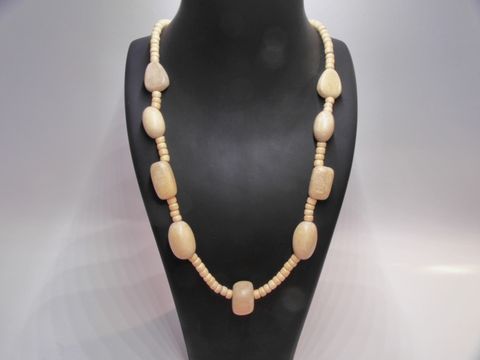Holzkette aus naturbraunem Holz, 20 mm dick, 60 cm lang, mit variierenden Perlenformen, präsentiert auf einem schwarzen Halter, ideal für stilvolle Accente. Hersteller Juwelier Harnisch.