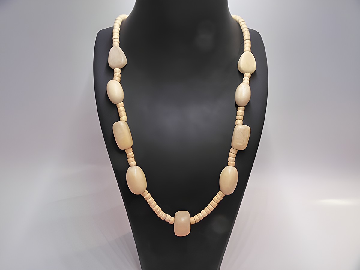 Holzkette aus naturbraunem Holz, 20 mm dick, 60 cm lang, mit variierenden Perlenformen, präsentiert auf einem schwarzen Halter, ideal für stilvolle Accente. Hersteller Juwelier Harnisch.