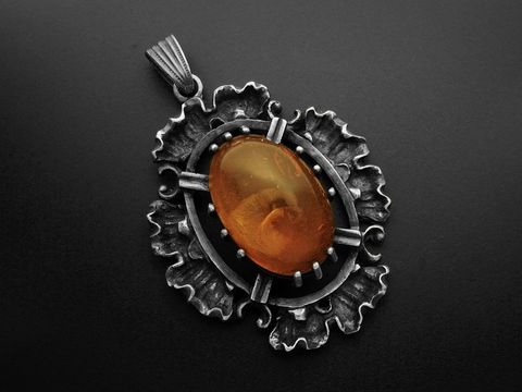 Anhänger echt Silber im ovalen vintage Look mit Bernstein, gefertigt vom Juwelier Harnisch. Der Anhänger zeigt ein kunstvolles Design und eine warme Bernsteinfarbe.