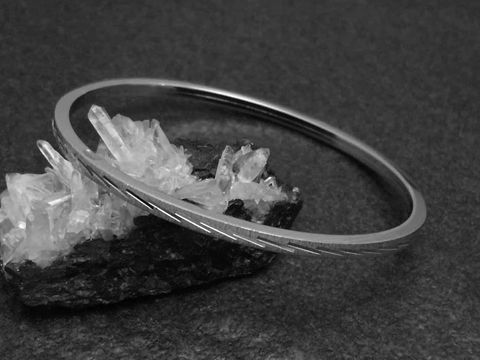 Silber Armreifen mit Diamantschliff, 3 mm, rhodiniert, 18 cm, Hersteller Juwelier Harnisch, auf glitzerndem Kristall dargestellt, elegant und zeitlos im Design.