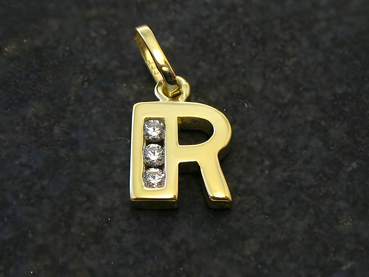 Goldener Anhänger in Form des Buchstabens R, verziert mit drei Zirkonia, Hersteller Juwelier Harnisch. Ideal zum persönlichen Schmuck.