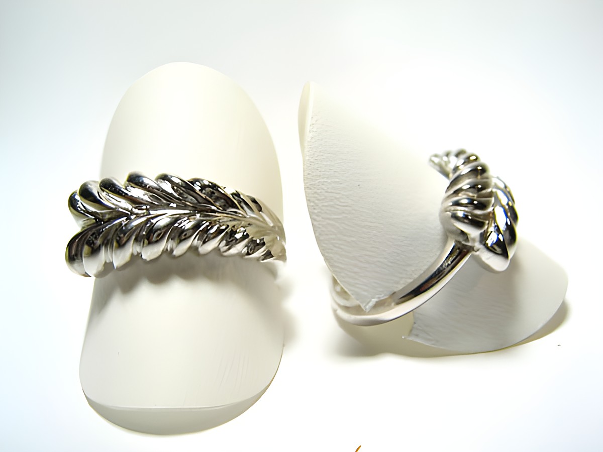 Silber Ring rhodiniert - schön - verstellbar, Hersteller: Juwelier Harnisch, ohne Stein, mit fließendem Design und elegantem Blattmuster, präsentiert auf zwei Ringkissen.