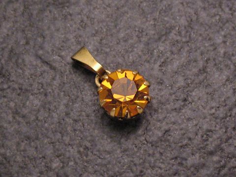 Gelber Strass Anhänger im sexy City Look, rund geformt, hergestellt von Juwelier Harnisch, glänzend mit goldfarbener Öse, ideal für stilvolle Akzente und besondere Anlässe.