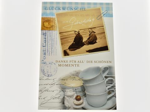 Eine Geburtstagskarte mit dem Motiv zweier Damen am Meer und der Aufschrift Glückwünsche zu deinem Geburtstag, gestaltet von Juwelier Harnisch.