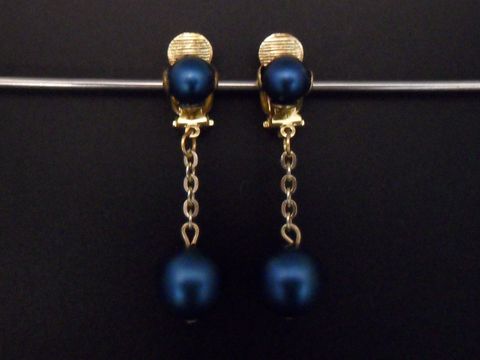 Wasserblaue, matte Ohrclips aus Kunstharz mit goldfarbenen Elementen, zeitloses Design, hergestellt von Juwelier Harnisch, ideale Ergänzung für stilvolle Outfits.