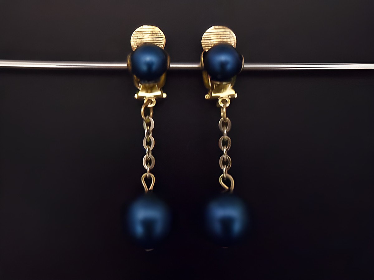 Wasserblaue, matte Ohrclips aus Kunstharz mit goldfarbenen Elementen, zeitloses Design, hergestellt von Juwelier Harnisch, ideale Ergänzung für stilvolle Outfits.
