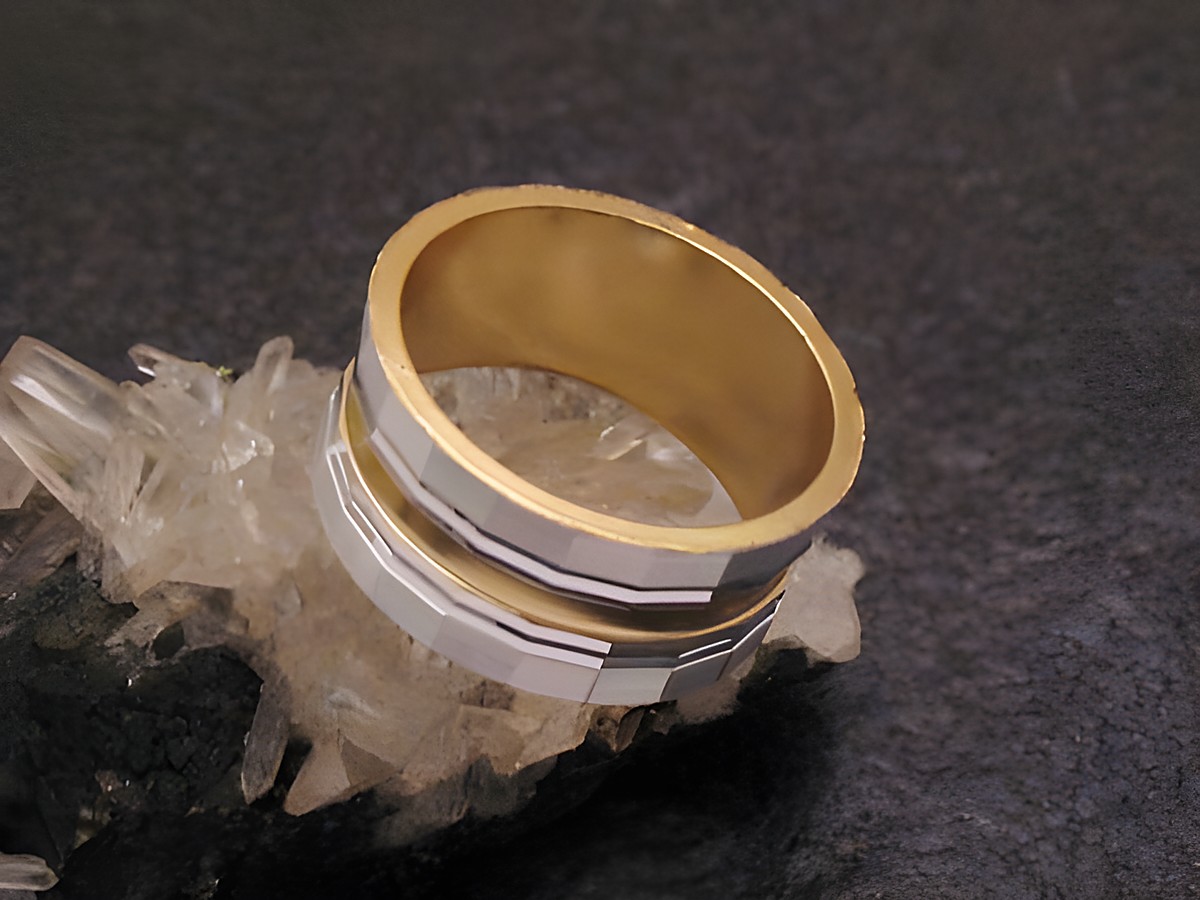 Bicolor Ring City Party Ring mit einer Breite von 9,7 mm und Größe 50 / 16 mm, gefertigt von Juwelier Harnisch, auf einem glitzernden Untergrund platziert.