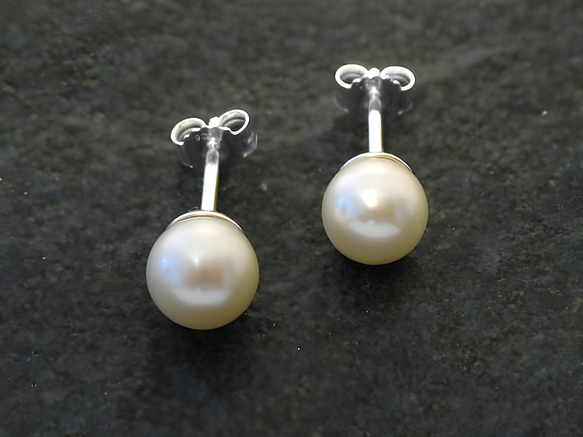 Perlenohrringe mit Zuchtperlen in 7 mm Durchmesser, gefertigt aus Sterling Silber, präsentiert auf dunklem Hintergrund, stilvoll und elegant, ideal für besondere Anlässe.