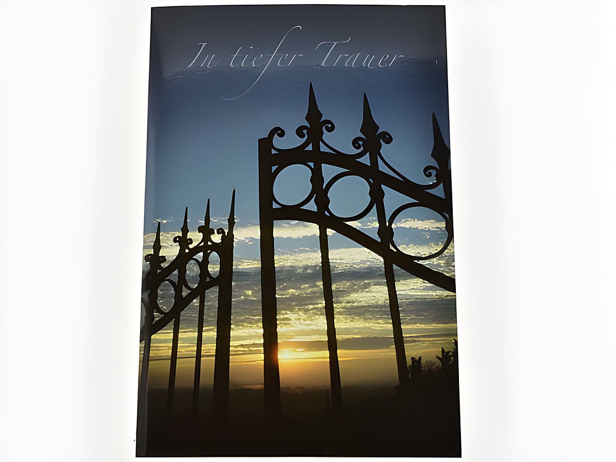 Ein Abendhimmel mit einem Tor im Vordergrund, die Farben des Sonnenuntergangs reflektieren Traurigkeit. Der Schriftzug In tiefer Trauer ist dezent platziert. Trauerkarte von Juwelier Harnisch.