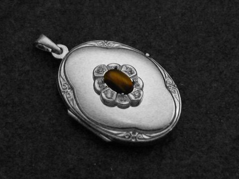 Tigerauge Medaillon Cabochon aus rhodiniertem Sterling Silber, filigrane Blütenstruktur um den Stein, elegantes Design von Juwelier Harnisch, hochwertige Verarbeitung.