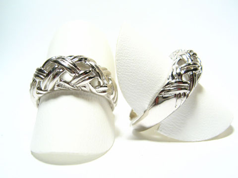 Silber Ring rhodiniert aus den 70er Jahren, verstellbar, Hersteller: Juwelier Harnisch, ohne Stein, mit ansprechendem Geflechtsdesign, auf weißen Ringpräsentern abgebildet.