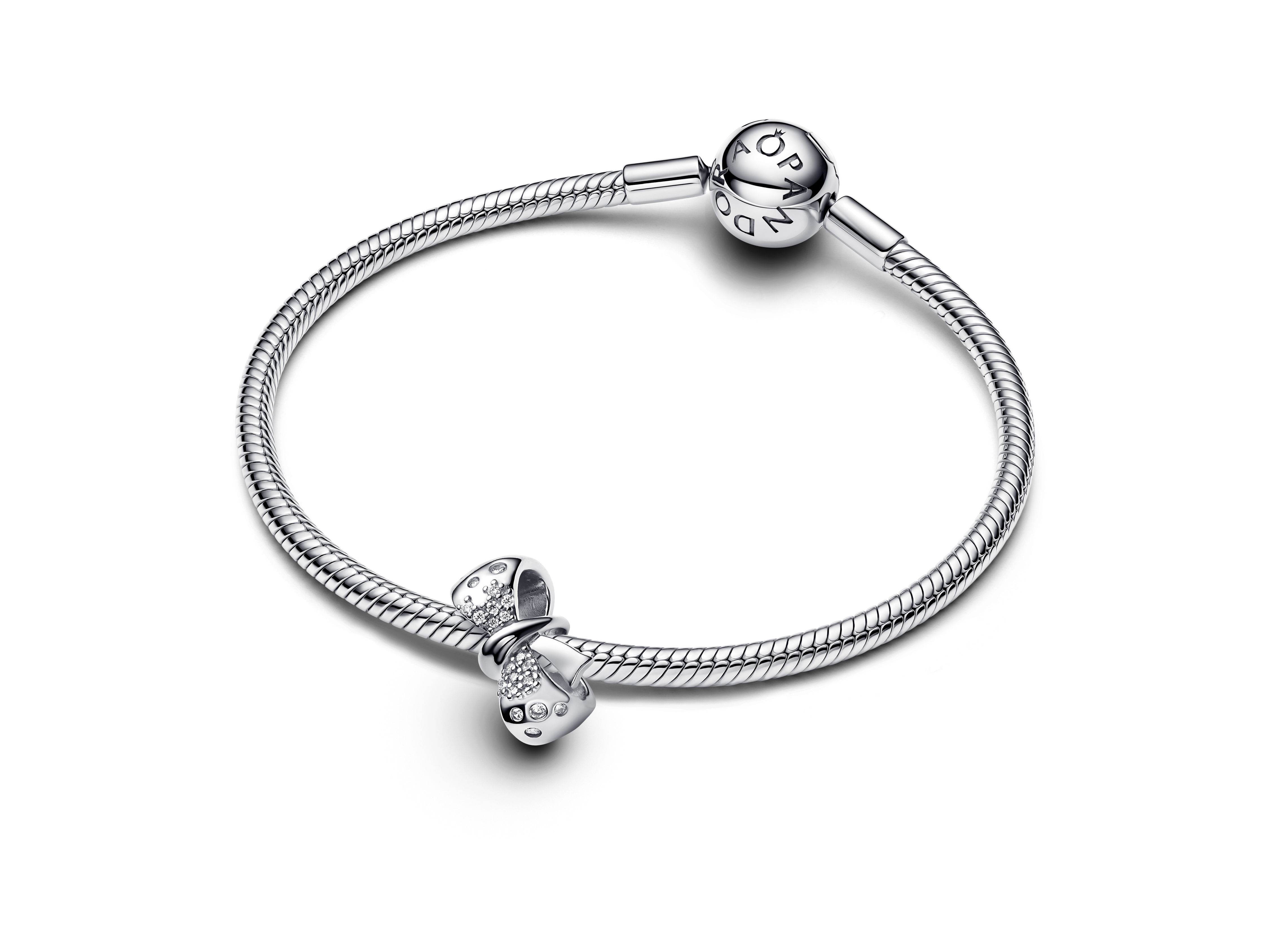Pandora 793442C01 Schleife Silberanhänger mit klarem Zirkonia auf einem silbernen Armband. Das Armband hat ein geflochtenes Design und zwei charakteristische Verschlüsse.