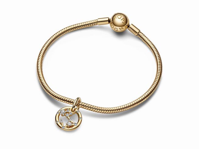 Sternzeichen Fische Charm-Anhänger aus gelbgold vergoldetem Material mit Zirkonia, befestigt an einem eleganten Armband von Pandora, strahlt zeitlosen Schmuckstil aus.