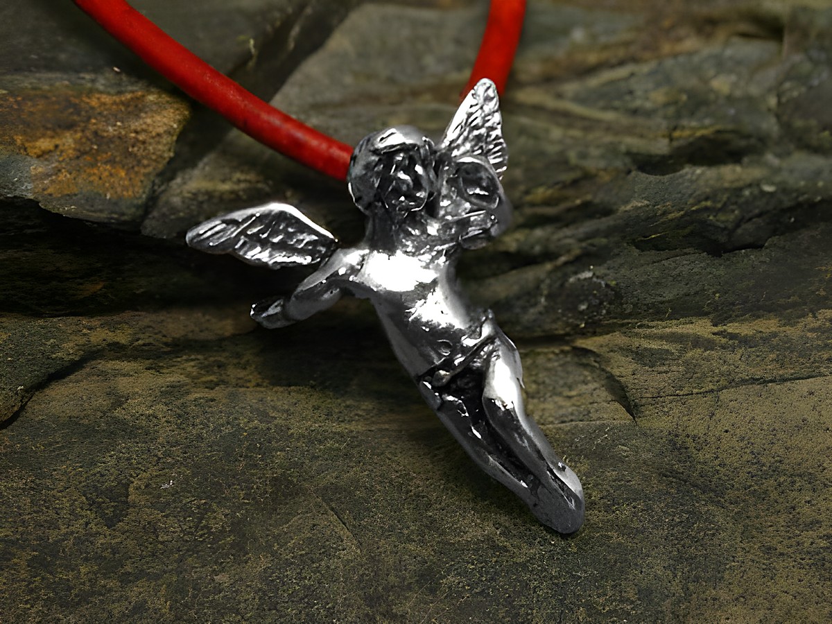 Engel aus Sterling Silber Anhänger mit detaillierten Flügeln, an einer roten Kette befestigt, elegant und symbolisch, Hersteller Juwelier Harnisch.
