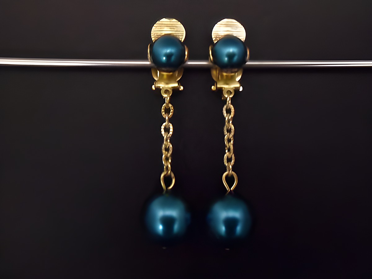 Ohrclip in türkisblau mit zeitlosem Design, verziert mit goldfarbenen Elementen und Kunstharz, hergestellt von Juwelier Harnisch, perfekt für eleganten Schmuck.