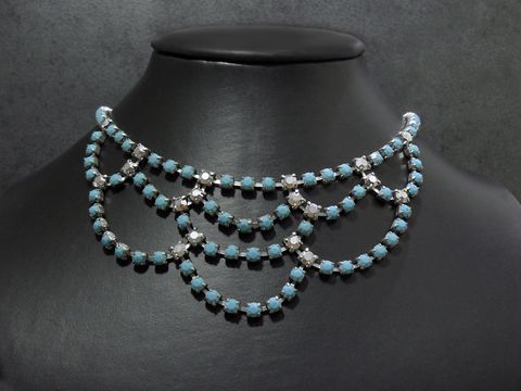 Auf dem Bild ist eine aufwendig gestaltete Strasskette in Türkis und silberfarben zu sehen. Die Kette hat eine Länge von 42 cm und eine silberfarbene Fassung, hergestellt von Juwelier Harnisch.