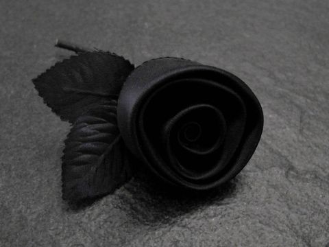 Haarschmuck und Brosche in Form einer zarten schwarzen Rose aus Satin, mit detaillierten Blättern, hergestellt von Juwelier Harnisch, ideal für festliche Anlässe.