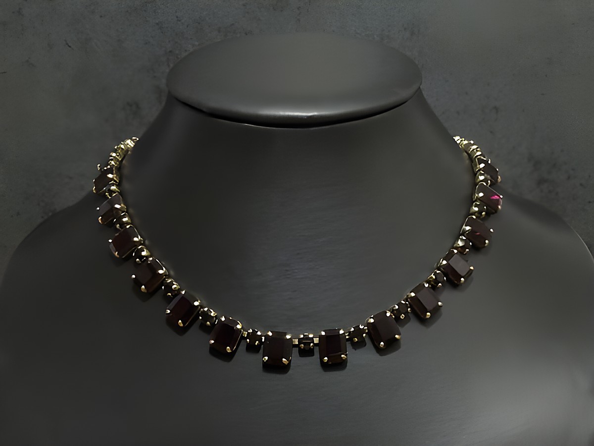 Strass Kette kultig in granatrot, 40-43 cm, goldfarben, von Juwelier Harnisch, mit goldfarbener Fassung, auf einem Schmuckständer präsentiert.
