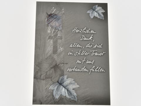Dankeskarte mit einem grauen Hintergrund, darauf sind Blätter und Laub in sanften Farben sowie ein Kreuz abgebildet. Der Text drückt Dankbarkeit und Verbundenheit in Trauer aus.