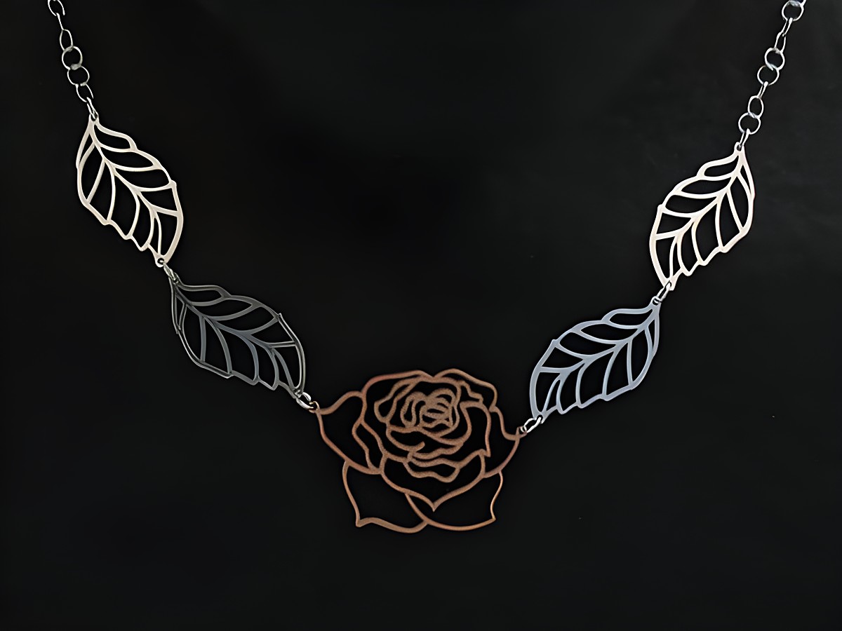 Kette aus Sterling Silber mit rosevergoldeter Rose als Mittelteil und filigranen Blättern, 45 cm lang, vom Hersteller Juwelier Harnisch, elegantes Schmuckstück für besondere Anlässe.