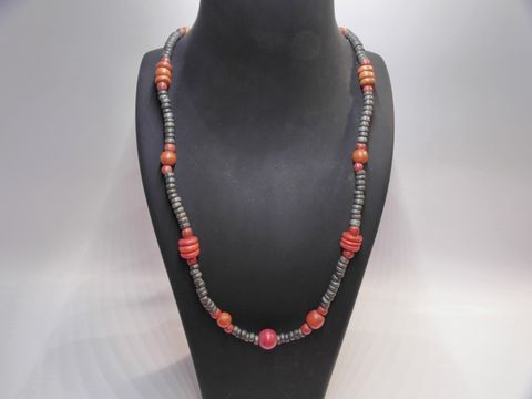 Holzkette Multiform 20 mm bunt 90 cm Holz Schmuck von Juwelier Harnisch, präsentiert auf einem schwarzen Schmuckhalter in ansprechender Farbkomposition.