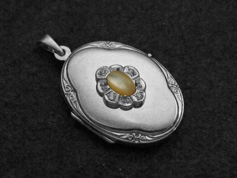 Perlmutt natur Medaillon Cabochon in ovaler Form, umgeben von einem blütenförmigen Rand aus Sterling Silber rhodiniert, hergestellt von Juwelier Harnisch, elegantes Schmuckstück.
