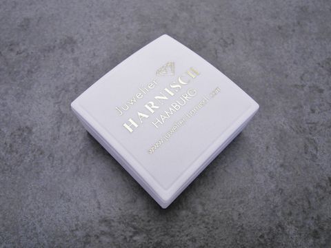 Geschenkschachtel 4 x 4 cm von Juwelier Harnisch in Weiß mit goldener Schrift und Firmenlogo, ideal für Schmuckpräsentationen und besondere Anlässe.