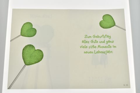 Geburtstagskarte mit aufgedruckten grünen Herzlollis und dem Text Zum Geburtstag alles Gute und ganz viele süße Momente im neuen Lebensjahr, Hersteller Juwelier Harnisch.