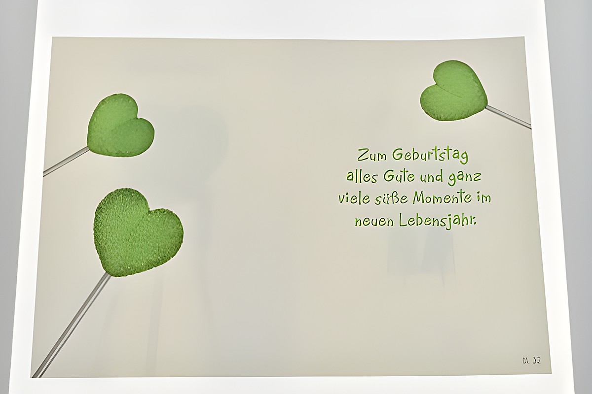 Geburtstagskarte mit aufgedruckten grünen Herzlollis und dem Text Zum Geburtstag alles Gute und ganz viele süße Momente im neuen Lebensjahr, Hersteller Juwelier Harnisch. – Ansicht 2