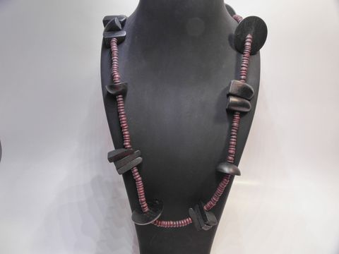 Holzkette Multiform 30 mm dunkelbraun-schwarz 90 cm Holz Schmuck von Juwelier Harnisch, braun-bunt mit stilvollen Holzperlen und dekorativem Design auf einem Schmuckständer präsentiert.