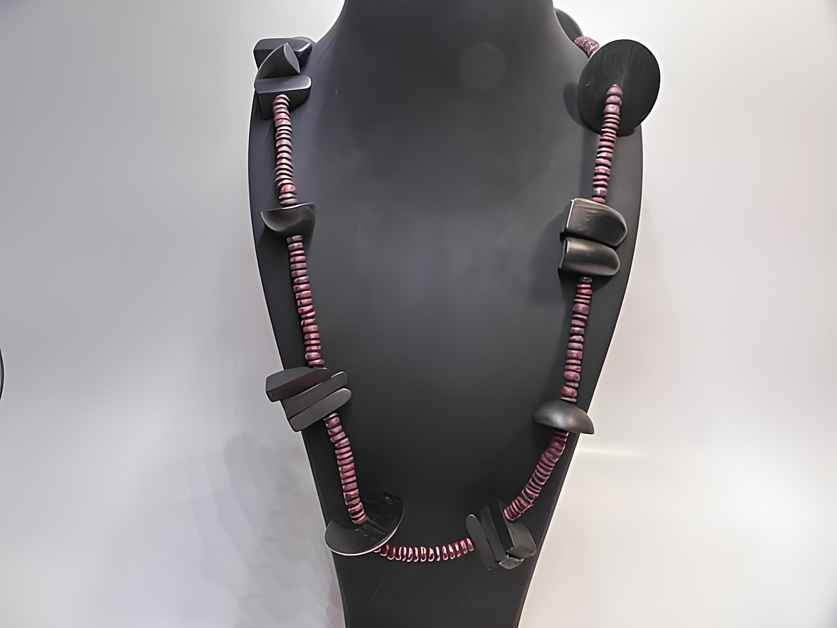Holzkette Multiform 30 mm dunkelbraun-schwarz 90 cm Holz Schmuck von Juwelier Harnisch, braun-bunt mit stilvollen Holzperlen und dekorativem Design auf einem Schmuckständer präsentiert.