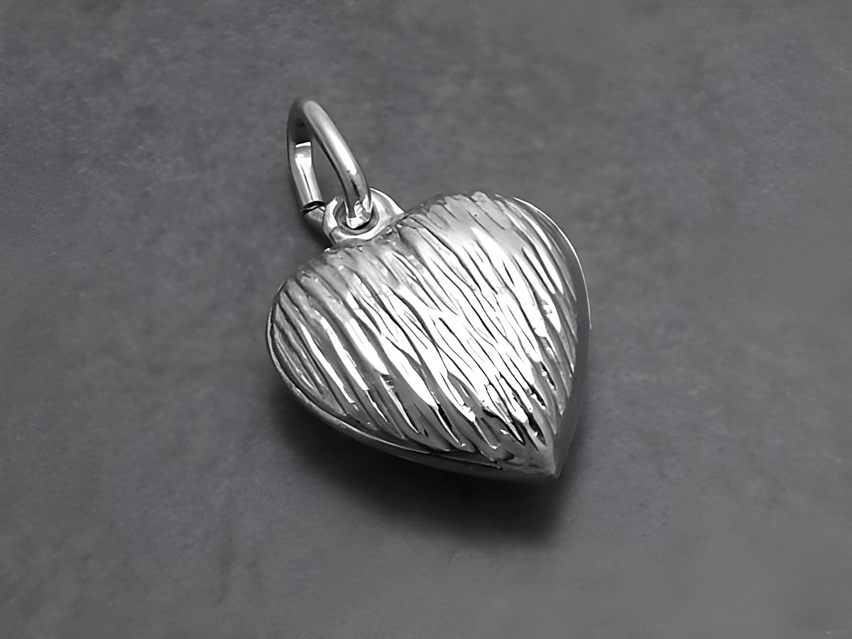 Kleiner süßer Silberanhänger in Herzform mit plastischem Muster, hergestellt von Juwelier Harnisch, ideal für persönlichen Schmuck oder als Geschenk.