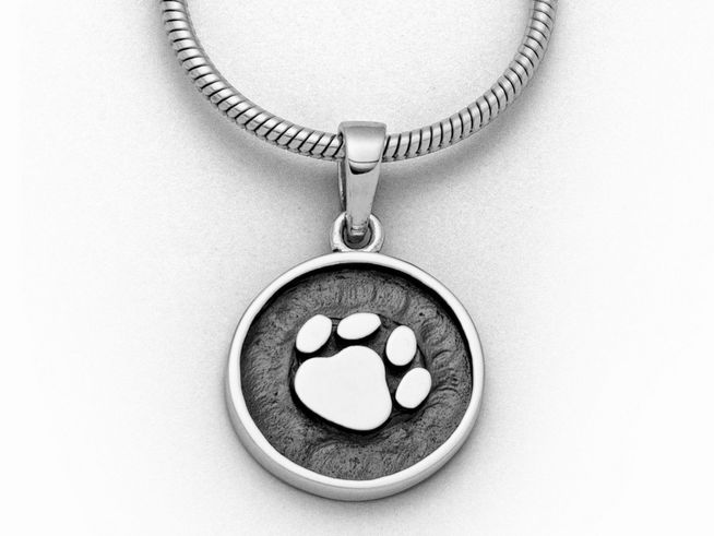 Sterling Silber Anhänger von DUR mit einem eingelassenen Hundepfotenmotiv, umrandet von einem kreisförmigen Silberrahmen, passend für eine Halskette von 22 cm.