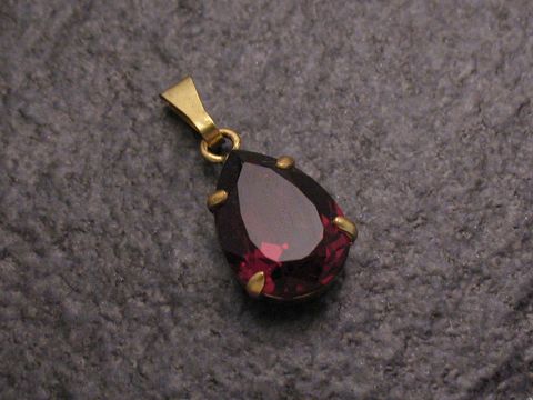 Roter Strass Anhänger im Tropfenformat mit goldfarbener Öse, ideal für einen sexy City Look, Hersteller Juwelier Harnisch, perfekt für vielfältige Anlässe.
