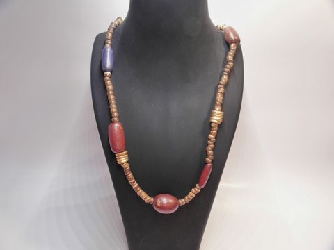 Buntes Holzschmuck mit einer Länge von 80 cm und bunten Holzkette in Multiform-Design, 24 mm, von Juwelier Harnisch, auf einem Schmuckständer präsentiert.