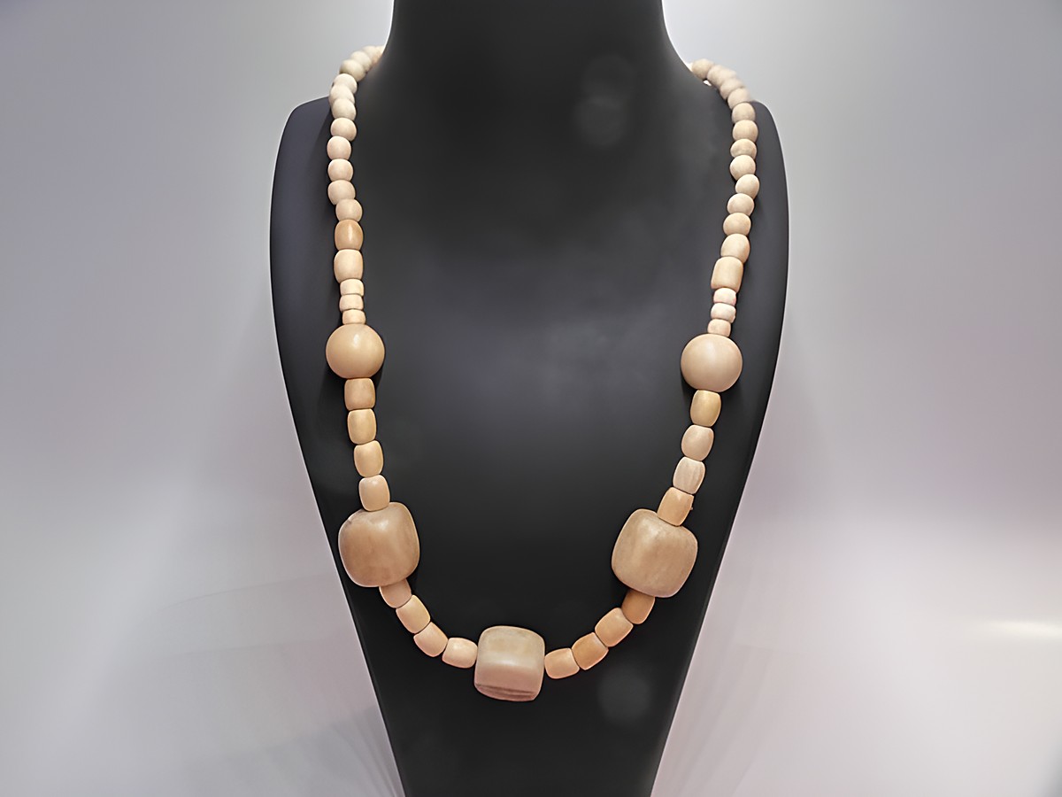 Holzkette Multiform 21 mm naturbraun 60 cm Holz Schmuck von Juwelier Harnisch, die auf einem Schmuckdisplay präsentiert wird, zeigt verschiedene Holzperlen in unterschiedlichen Formen und Größen.