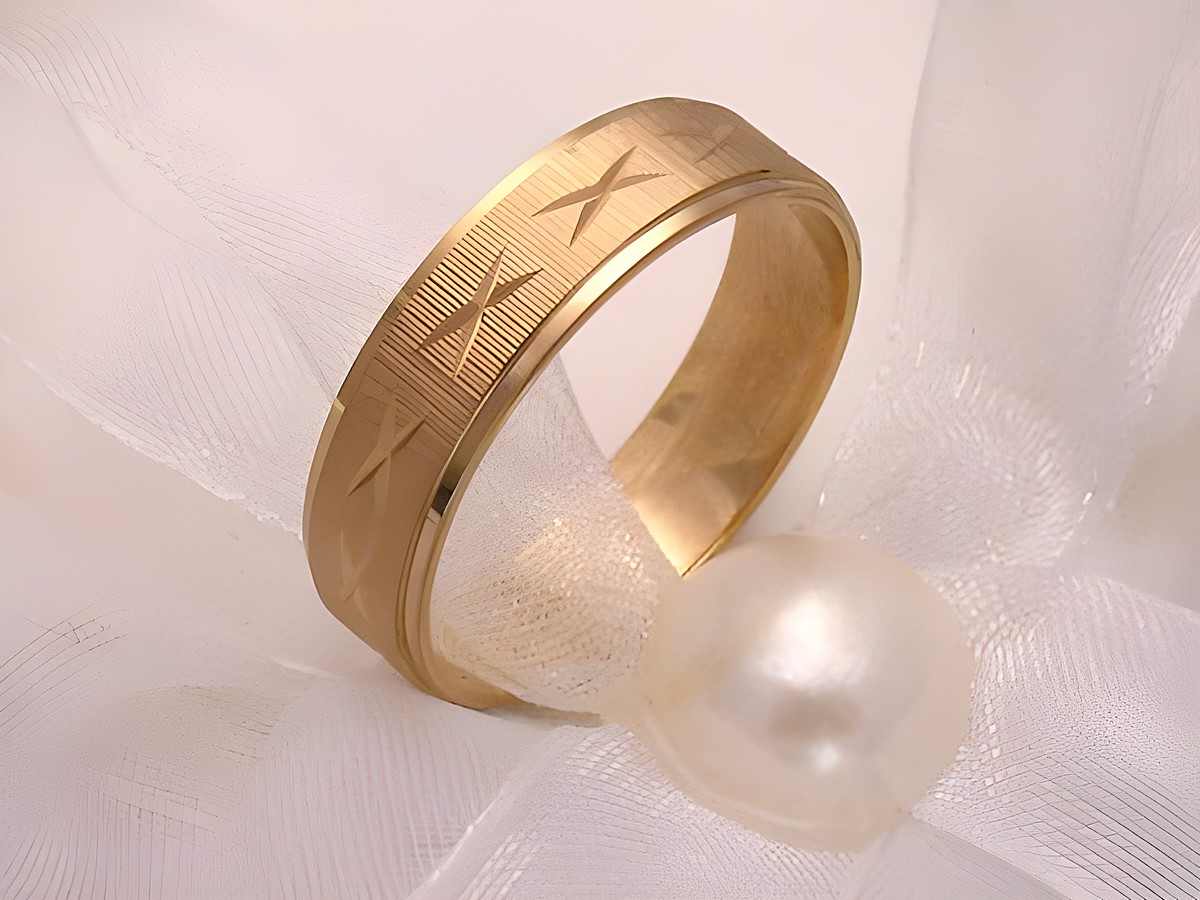 Trauring Ehering CROSS aus Gold 333 in Größe 55 17,5 von Juwelier Harnisch, bis Größe 56 17,8, mit eingravierten Mustern auf einer eleganten Unterlage aus Tüll und einer Perle.