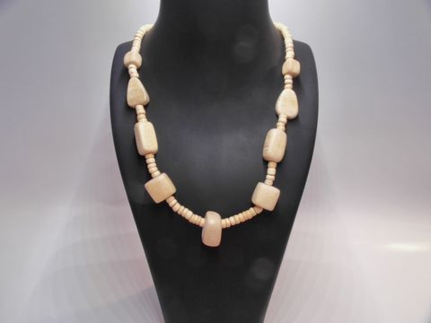 Holzkette aus naturbraunem Holz mit verschiedenen Formen, 20 mm dick und 60 cm lang, präsentiert auf einem dunklen Schmuckständer, Hersteller Juwelier Harnisch.